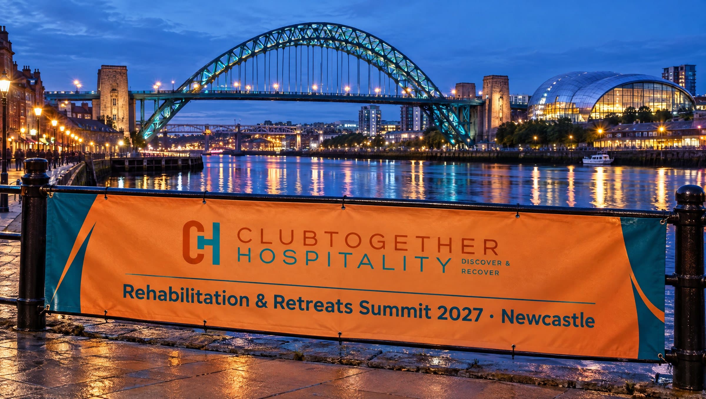 A summit banner on the Quayside railings with the Tyne Bridge lit up at night